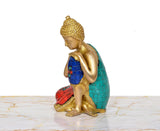 Brass Buddha idol sitting sideways view, blue top with red and teal mosaic accents