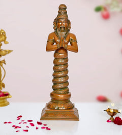 Brass Patanjali statue with hands in prayer, standing on ornate pedestal base.