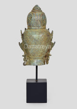 Back view of vintage bronze Lord Vishnu head idol with detailed back ornament, on base