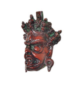 Angled view of multicolored Brass Mahakala wall hanging mask, sculpted facial features