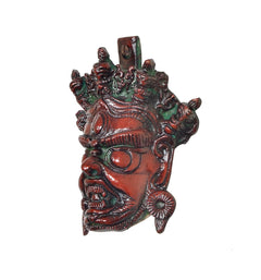 Angled view of multicolored Brass Mahakala wall hanging mask, sculpted facial features
