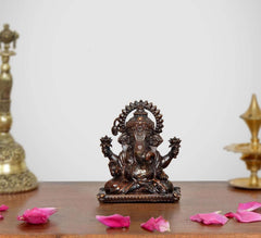 Small sitting Lord Ganesha brass idol with ornate crown and four raised arms