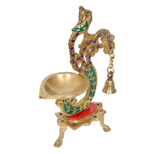 Brass peacock diya oil lamp with large bowl, teal-green enamel accents, and red base