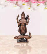 Copper standing deity murti from rear angle, peacock body on pedestal base
