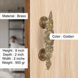 Golden brass door handle pair, close-up of circular rosettes and etched scrollwork