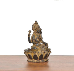 Copper Lakshmi idol in side view, raised hands, lotus base with textured edges