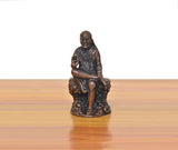 Seated Shirdi Sai Baba figurine in dark copper finish, raised right hand
