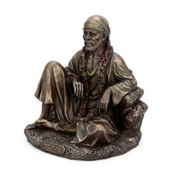 Resin Shirdi Sai Baba statue from side view, seated pose on rocky base