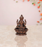 Copper Lakshmi statue idol, seated upright on lotus petals, decorative draped attire