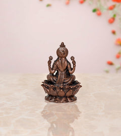 Copper Lakshmi statue idol, seated upright on lotus petals, decorative draped attire