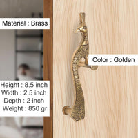 Golden brass peacock door handle pair on light wood, ornate textured body; 8.5 in height