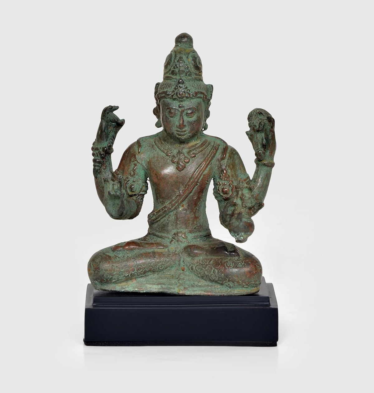 Vintage bronze Lord Vishnu statue, seated with four arms raised, on dark wooden base