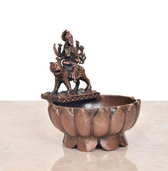 Copper-toned Durga Maa urli bowl, side view of seated deity and animal mount