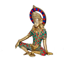 Side view of Indra Dev brass idol, seated pose, blue-red halo, green and red jewelwork
