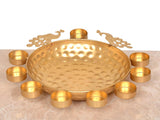 Gold hammered decorative urli bowl with embossed texture and surrounding tea light holders