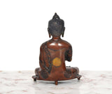 Brass Buddha statue from back, seated posture on base with dark back detailing