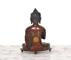 Brass Buddha statue from back, seated posture on base with dark back detailing
