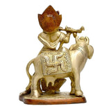 Brass Krishna and cow idol statue, side view, decorative embossed details