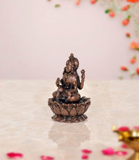 Copper Lakshmi statue, side/back view seated on lotus with raised hands