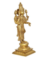 Brass Lakshmi goddess figurine side view, holding symbolic staffs, on raised pedestal base.