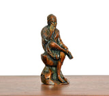 Angled brass Shirdi Sai Baba statue seated, side view of robe and arms