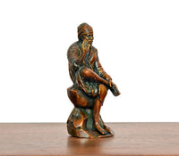 Angled brass Shirdi Sai Baba statue seated, side view of robe and arms