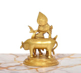 Brass Krishna with flute statue on cow, view from rear showing cow and base