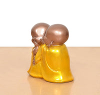 Resin laughing Buddha sculpture, side view of two monk figures in glossy yellow robes