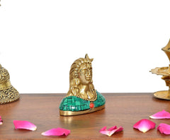 Brass Adiyogi Shiva idol, three-quarter view, green mosaic robe and red bead
