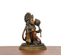 Seated brass Hanuman JI idol from rear side, raised ornaments and long tail, on base