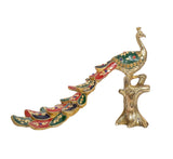 Side view of multicolor brass peacock figurine with jeweled eye pattern and long tail
