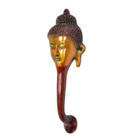 Buddha-face door handle from front-left, gold face and dark beaded crown
