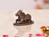 Copper Nandi cow idol on base, front view facing left with garland details