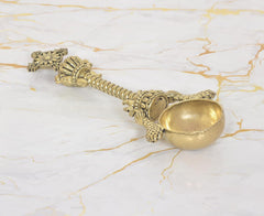 Bronze Achmani Patra spoon with decorative Vishnu-style emblem on the handle