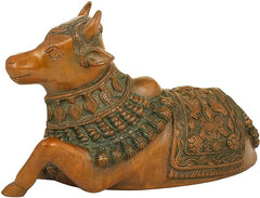 Brass Nandi figurine on side view, green-and-gold patterned saddle and collar