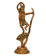 Brass Krishna dancing figure with bow-shaped halo and lifted arms, cobra behind