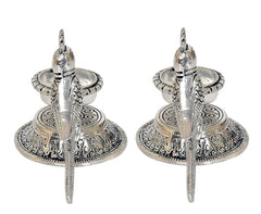 Front view of two silver parrot diyas with central wicks and embossed circular trays