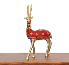 Front view brass reindeer statue with red painted body, blue bead border, and gold antlers