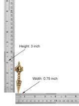 Brass dorje vajra furba next to ruler, height 3 in and width 0.75 in