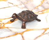 Handcrafted brass tortoise figurine, 1.5 in, angled view showing legs and tail
