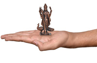 Copper deity murti held in palm for scale, standing with peacock, detailed pedestal base