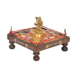 Brass Shiva seated on round pedestal atop decorated chowki with red rope trim