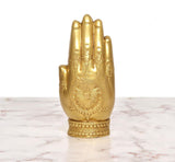 Golden brass blessing hand Ganesha idol from the front, with carved palm and halo pattern.