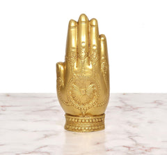 Golden brass blessing hand Ganesha idol from the front, with carved palm and halo pattern.