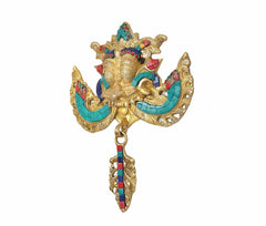 Brass Kirtimukha wall hanging with gold face, turquoise arm panels, and central tassel