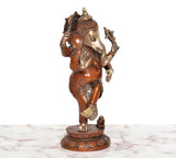 Brass dancing Ganesha idol, four arms and gold-toned ornaments, on round base