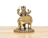 Rear three-quarter view: bronze deity standing on bull on ornate circular pedestal