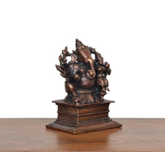 Copper Ganesha with Riddhi idol, seated on ornate pedestal, side profile view