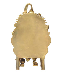 Golden brass back of seated Ganesha idol with decorative halo shape