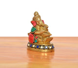 Brass Ganesha statue blowing conch shell, rear side view, multicolor decorated base